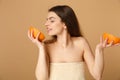 Close up beauty half naked woman 20s with perfect skin nude make up hold grapefruit isolated on beige pastel wall