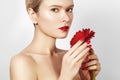 Close-up beauty photo woman with red lips, lipstick and beautiful red flower. Spa clean skin Royalty Free Stock Photo