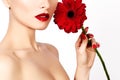 Close-up beauty photo woman with red lips, lipstick and beautiful red flower. Spa clean skin Royalty Free Stock Photo