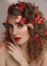 Close up beauty portrait of attractive curly blonde girl with red lips and butterflies in her hair, young female Royalty Free Stock Photo