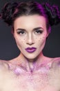 Close up beauty portrait of a fantasy art theme: Star Wars cosplay. Princess Leia hairstyle with purple glitters and stars all Royalty Free Stock Photo