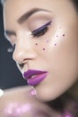 Close up beauty portrait of a fantasy art theme: Star Wars cosplay. Princess Leia hairstyle with purple glitters and stars all Royalty Free Stock Photo