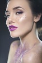 Close up beauty portrait of a fantasy art theme: Star Wars cosplay. Princess Leia hairstyle with purple glitters and stars all Royalty Free Stock Photo