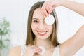 Close up beauty portrait of a smiling attractive woman cleaning her face with a cotton pad isolated over light Royalty Free Stock Photo