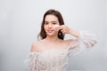 Close up beauty portrait of a smiling attractive woman cleaning her face with a cotton pad isolated over white background Royalty Free Stock Photo