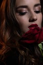 Close up beauty portrait of young beautiful woman with a rose in hand. Studio shot Royalty Free Stock Photo