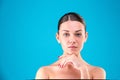 Close up Beauty portrait of young woman brunette smiling and touching her face on blue background. Perfect Fresh Skin Royalty Free Stock Photo