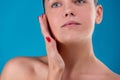 Close up Beauty portrait of young woman brunette smiling and touching her face on blue background. Perfect Fresh Skin Royalty Free Stock Photo