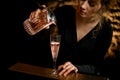 Close-up. Beauty woman at bar attentively pours drink into glass Royalty Free Stock Photo