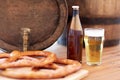 Close up of beer barrel, glass, pretzel and bottle