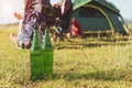 Close up of beer bottle in meadow while camping at outdoors. Holiday and Vacation concept. Adventure and outdoors theme