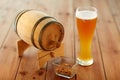 Close up of beer glass, peanuts and wooden barrel