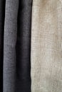 Close-up of beige and black curtains thin and thick vertical folds of dense fabric. Textured abstract backgrounds and