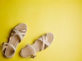 Close up of beige leather summer comfortable women`s sandals on brigth yellow background. Top view, flat lay, horizontal Royalty Free Stock Photo