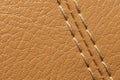 Close-up of beige orange faux leather stitching in the car interior. Background for interior trim comfort