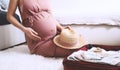 Close-up belly of pregnant woman with travel bag of clothes and necessities. Mother during pregnancy preparing and packing Royalty Free Stock Photo
