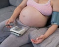 Close-up of the belly of a pregnant woman measuring blood pressure with a tonometer. Hypotension. Royalty Free Stock Photo