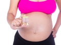 Close-up belly of pregnant woman with urine bottle on white back