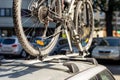 Close-up bicycle on car roof rack railing at outdoor parking. Vehicle with mounted bike on rooftop. Active sport touristic trip co Royalty Free Stock Photo