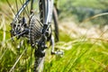 Close-up of the bicycle wheel in the summer green grass in the field.