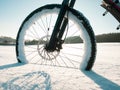 Close up of bicycle wheel on white snow. Cycling in extreme winter conditions