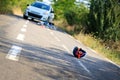 Close-up of a bicycling helmet fallen on the asphalt next to a b