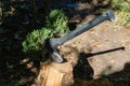 Close-up of big axe chopping oak stumps in the garden. Preparing firewood for a stove or fireplace for the winter