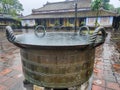 Close-up of a big decorated metal pot at Thien Mu Pagoda on a heavy rain day. Hue, Vietnam Royalty Free Stock Photo