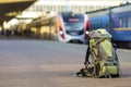 Close-up of big green tourist backpack on railway station platform on blurred background. Traveling, adventure and recreation Royalty Free Stock Photo