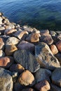 Close up of big stones of Baltic sea shore. Sunny day and dark green navy sea water in diagonal. Reidi tee, Tallinn