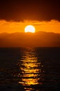 Close up big Sun set, Sunrise with the cloud and mountain layer at the sea., Thailand Royalty Free Stock Photo