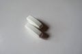 Closeup of 2 big white oblong caplets of calcium citrate Royalty Free Stock Photo