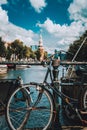 Close-up of Bike parked on a bridge in Amsterdam, Netherlands. Typical cityscape with Amstel river and motion clouds at the Royalty Free Stock Photo