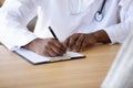 Close up of biracial doctor write prescription in medical card