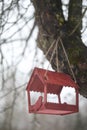 Close-up of a bird feeder on a tree under the snow in the forest. Royalty Free Stock Photo