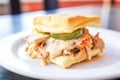 a close-up of a biscuit sandwich with gravy as the filling