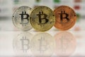 Close up of Bitcoins, gold bitcoin, silver bitcoin and bronze bitcoin with blurred background of world flags. reflection Royalty Free Stock Photo