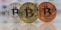 Close up of Bitcoins, gold bitcoin, silver bitcoin and bronze bitcoin with blurred background of world flags. reflection Royalty Free Stock Photo
