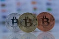 Close up of Bitcoins, gold bitcoin, silver bitcoin and bronze bitcoin with blurred background of world flags. reflection Royalty Free Stock Photo