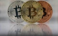 Close up of Bitcoins, gold bitcoin, silver bitcoin and bronze bitcoin with blurred background of world flags. reflection Royalty Free Stock Photo