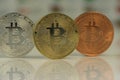 Close up of Bitcoins, gold bitcoin, silver bitcoin and bronze bitcoin with blurred background of world flags. reflection Royalty Free Stock Photo