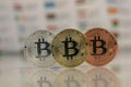 Close up of Bitcoins, gold bitcoin, silver bitcoin and bronze bitcoin with blurred background of world flags. reflection Royalty Free Stock Photo