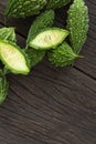 Close up Bitter melon bitter gourd cucumber or Momordica charantia in wooden bowl isolated on old wood table Royalty Free Stock Photo