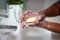 close up of black African Australian woman washing hands with a bar of soap Royalty Free Stock Photo