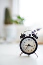 Close-up of black alarm clock with lavender flower, on bokeh background Royalty Free Stock Photo