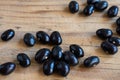 Close-up of black beans caricos on rustic wooden table, selective focus, horizontal,