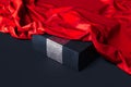 Close up of black blank box under red cloth on black background. 3d rendering.