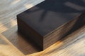 Close up of black blank business cards set isolated on wooden background, 3d rendering.