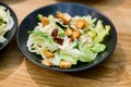 Close-up of bowl of caesar salad placed on wooden table Royalty Free Stock Photo