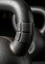 Close-up of a black cast iron kettlebell handle. The handle features a textured, cross- Royalty Free Stock Photo